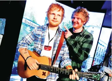  ??  ?? Nico Eckl (right), lookalike of Ed Sheeran poses beside a wax figure of musician Ed Sheeran in the Madame Tussauds wax museum in Berlin, Germany on Tuesday. — Reuters photos
