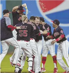  ?? AP PHOTO ?? STILL MAKING A SPLASH: The Indians celebrate after a walkoff double by Jay Bruce (center) in the 10th inning gave them their 22th consecutiv­e victory last night.