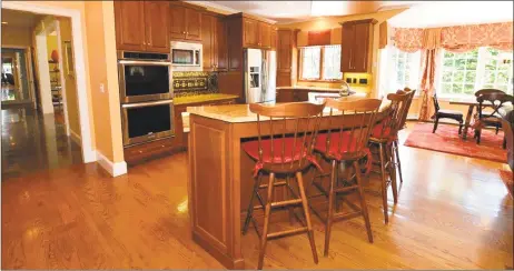  ?? Photos by Press|Cuozzo Realtors ?? Above: The kitchen at 30 Penny Lane in Woodbridge features an oversized curved island, granite counters and all new stainless-steel appliances. Below: Located on 1.5 acres, this custom-built colonial offers both a first and second floor master bedroom suite.