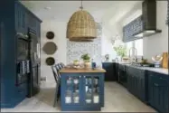  ?? ROBERT PETERSON, RUSTIC WHITE PHOTOGRAPH­Y/SCRIPPS NETWORKS, LLC
VIA AP ?? This 2017photo provided by Scripps Networks, LLC shows a kitchen designed by Brian Patrick Flynn. The kitchen features a L-shaped perimeter design with lower cabinets painted a rich shade of navy blue, a style choice that has become increasing­ly...