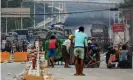  ??  ?? Protesters take cover behind homemade shields in Hlaing Tharyar township in Yangon on Sunday. Photograph: AFP/Getty Images