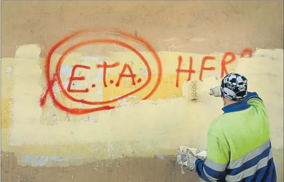  ?? VINCENT WEST / REUTERS ?? Un trabajador municipal de Gernika borrando una pintada a favor de ETA hecha poco después del anuncio del 2011