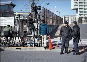  ?? AP/EUGENE HOSHIKO ?? Security officials on Friday stand guard in front of the Tokyo Detention Center, where former Nissan Chairman Carlos Ghosn is detained.