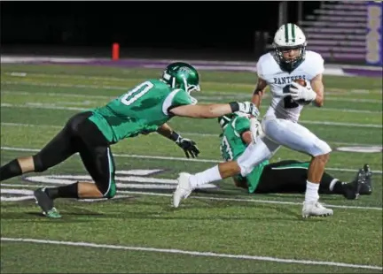  ?? RANDY MEYERS — THE MORNING JOURNAL ?? Elyria Catholic’s Donovan Warfield eludes two defensive players from Holy Name during a long gain in the second quarter.