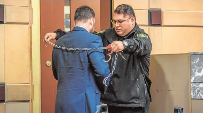  ?? EFE ?? Un alguacil coloca la cadena y las esposas al español Pablo Ibar durante la última sesión del juicio celebrado en Fort Lauderdale (Florida)