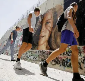  ?? LaPresse ?? Turisti Visitatori al Muro del pianto e il murale dell’artista italiano Jorit Agoch
