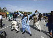  ?? ANJUM NAVEED / AP ?? Supporters of former Prime Minister Imran Khan of Pakistan chant anti-government slogans during clashes in Islamabad on Saturday after police stormed Khan’s residence and arrested 61 people.