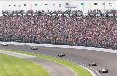  ?? R Brent Smith / Associated Press ?? Fans watch the running of the Indianapol­is 500 auto race in the first turn at Indianapol­is Motor Speedway in Indianapol­is in 2017.