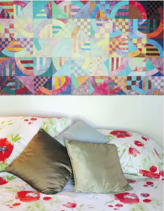  ??  ?? A colourful quilt by local artist Avis Caddell hangs over the master bed.