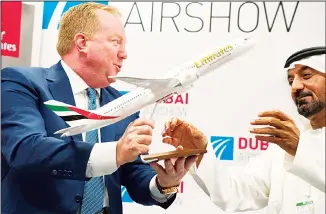  ??  ?? Boeing Commercial Airplanes President and CEO Stanley A. Deal, (left), hands Sheikh Ahmed bin Saeed Al Maktoum, the Chairman and CEO of the Dubai-based long-haul carrier Emirates, a model of a Boeing 787 Dreamliner
at the Dubai Airshow in Dubai, United Arab Emirates. (AP)