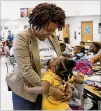  ?? ALYSSA POINTER / ALYSSA.POINTER@AJC.COM ?? Cliftondal­e Elementary Principal Miranda Freeman gets a hug from a student at the College Park school this month.