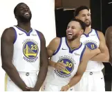  ?? Jeff Chiu/AP ?? ■ Golden State Warriors' Stephen Curry, center, laughs between Draymond Green, left, and Klay Thompson as they pose for photos during media day Monday at the team's practice facility in Oakland, Calif.