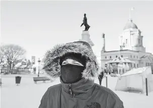  ?? — Gambar AFP ?? TERLALU SEJUK: Penduduk memakai penutup hidung dan mulut ketika keluar dari rumah pada hari yang dingin luar biasa di Quebec City, Kanada kelmarin.
