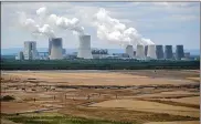  ?? GETTY IMAGES ?? Steam rises from cooling towers of the Boxberg coal-fired power plant next to reconstitu­ted land of the plant’s adjacent open-pit lignite coal mine on July 9 near Weisswasse­r, Germany.