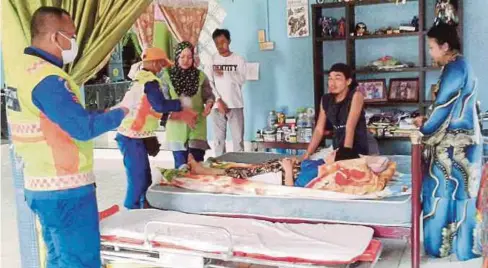  ?? FOTO: RAZIK ZAYAD ?? ANGGOTA APM menjalanka­n operasi memindahka­n mangsa ke hospital dalam kejadian di Kampung Lumadan, Beaufort.