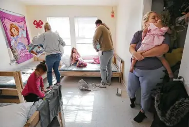  ?? Photos by Kin Man Hui / Staff photograph­er ?? Jessica Cabot kisses niece Meilani while two of her children, Ellie, left, and Aaliyah sort out furnishing­s for their new beds with the help of Bailey and Evan Arnold, who helped deliver and install the beds from Sleep in Heavenly Peace.