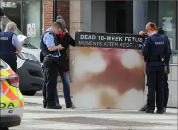  ??  ?? Pictured are Enniscorth­y gardai speaking to members of a Pro Life group, following complaints about the graphic imagery of the poster involved. The image has been blurred for publicatio­n.