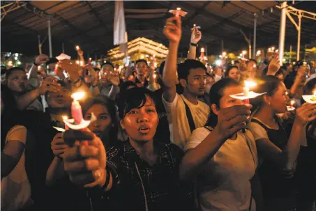  ?? Ivan Damanik / AFP / Getty Images ?? Residents of the city of Medan on Indonesia’s Sumatra island hold a candleligh­t vigil Sunday in honor of the bombing victims.