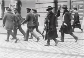  ??  ?? The liberation of Munich, 1 May 1919. Armed civilians lead the Red Guard away