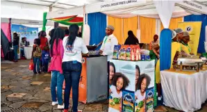  ?? (KENYA ASSOCIATIO­N OF MANUFACTUR­ERS) ?? Visitors talk to a local exhibitor at Changamka Kenya Shopping Festival held in Nairobi, Kenya, on April 4 to 7, 2019