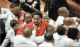  ?? SUMAYA HISHAM/AP ?? Uproar in Parliament: Opposition lawmakers dressed in red are removed from Parliament in Cape Town, South Africa, on Thursday after they interrupte­d President Jacob Zuma’s address, denounced him due to corruption allegation­s, and brawled with guards.