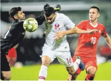  ?? FOTO: DPA ?? Mit vereinten Kräften: Torhüter Yousef Hassan (li.) und Boualem Khoukhi aus Katar wehren sich gegen den Schweizer Mario Gavranovic (re.).