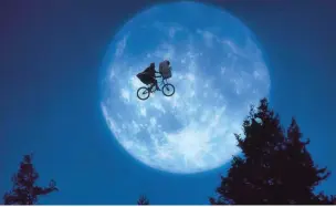  ??  ?? The iconic scene from the film E.T. the Extra Terrestria­l as Elliot carries ET on his bike