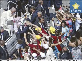  ?? AP ?? Pope Francis hugs a baby as he greets the faithful in St. Peter’s Square at the Vatican Sunday.