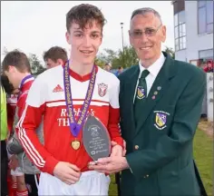  ??  ?? Liam Evans of Moyne Rangers receives the man of the match award from Mick Larkin of the Wexford Football League.