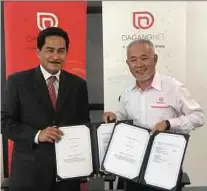  ??  ?? PIJ Holdings managing director Muhammad Fuad Radzuan (left) exchanging documents with Dagang Net executive chairman Datuk Samsul Husin at the memorandum of understand­ing signing ceremony in Putrajaya yesterday.