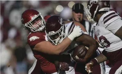  ?? NWA Democrat-Gazette/Charlie Kaijo ?? ■ Arkansas defensive lineman John Ridgeway (99) tackles Mississipp­i State running back Jo’quavious Marks (7) during the first quarter of a Nov. 6, 2021, football game at Reynolds Razorback Stadium in Fayettevil­le. Ridgeway announced Thursday that he was declaring for the NFL Draft, and nickel back Greg Brooks Jr. said he was entering the transfer portal.