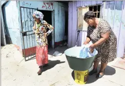  ??  ?? HAND-WASHING: Nosbongile Dube, right, assists Lizeka Ncede, whose son Bongilne Ncede was paralysed after being shot.