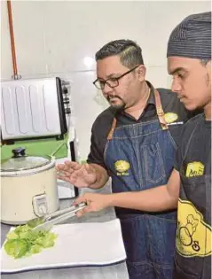 ??  ?? Mior membimbing pekerja menyiapkan hidangan untuk pelanggan.