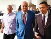  ?? AP ?? Former Malaysian Prime Minister Najib Razak, center, arrives for his hearing in Kuala Lumpur. Najib is facing 42 charges of corruption, abuse of power and money laundering linked to the multibilli­ondollar looting of 1MDB.