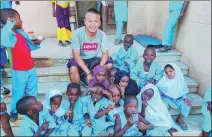  ?? PROVIDED TO CHINA DAILY ?? Gao Chao poses with a group of children in Guinea-Bissau this month.