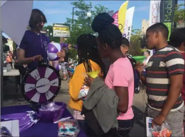  ?? BRIANA CONTRERAS — THE MORNING JOURNAL ?? Youngsters participat­e in a spin the wheel activity at One Wireless and MetroPCS’s Customer Appreciati­on Day event at their W. 4th St. location in Lorain on June 2. The event offered free raffles and prizes, ice cream and fun.