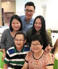  ?? — Stephanie LOW ?? Stephanie (standing, left), and Cherish (standing, right) are proud of their parents Lee (seated, right) and timothy (seated, left), who taught them to have empathy. With them is family friend max Fang (back).