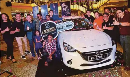  ?? PIC BY NURUL SHAFINA JEMENON ?? Revolusi Watch and Win Mazda Contest winner Vasantha Govindaraj­o (sixth from left) with her family at Berjaya Times Square in Kuala Lumpur on Saturday. Present are Infinitus Production­s executive producer Gayatri Su-Lin Pillai (left), actor Zul Ariffin...