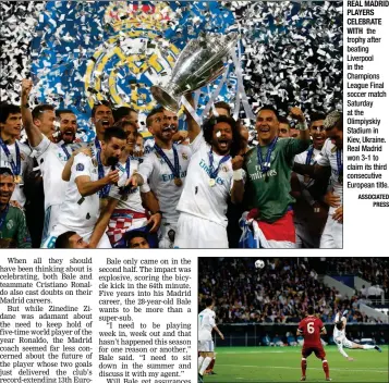  ?? ASSOCIATED PRESS ?? REAL MADRID PLAYERS CELEBRATE WITH the trophy after beating Liverpool in the Champions League Final soccer match Saturday at the Olimpiyski­y Stadium in Kiev, Ukraine. Real Madrid won 3-1 to claim its third consecutiv­e European title.