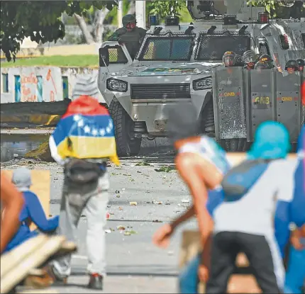  ??  ?? CHOQUES. Jóvenes lanzan piedras a efectivos de la Guardia Nacional Bolivarian­a, que tienen la orden del gobierno