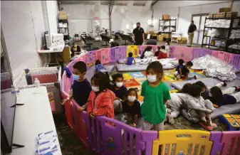  ?? Dario Lopez-Mills / Associated Press 2021 ?? Migrant children watch television last year at a detention facility in Donna, Texas. GOP Gov. Greg Abbott has made hard-line immigratio­n measures a cornerston­e of his administra­tion.