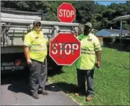  ?? SUBMITTED PHOTO ?? Valley Township Streets Department employees Brian Myers and Josh Waltrop covered up racial graffiti on Wednesday that was painted on West 10th Avenue in the township. They replaced a stop sign that was vandalized by the alleged suspect who painted a...