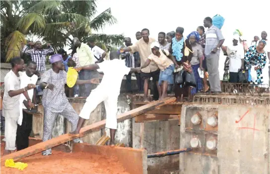  ?? PHOTO ?? Residents of Ijegun and Isheri -Oshun trying to cross a plank to Isolo Road in Lagos yesterday.
NAN