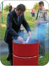  ??  ?? United States Congressma­n Mike Fitzpatric­k (R8), properly disposes of a portion of an American flag by placing it in a fire Friday evening.