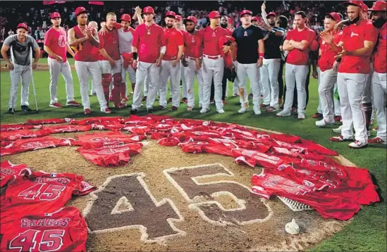  ?? Kent Nishimura Los Angeles Times ?? THE ANGELS ALL WORE Tyler Skaggs’ No. 45 jersey during the game, and they spread them on the mound after their combined no-hitter against the Mariners.