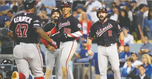  ?? HARRY HOW/GETTY IMAGES ?? Washington Nationals slugger Howie Kendrick, middle, celebrates after hitting the game-winning grand slam against the Los Angeles Dodgers on Wednesday.