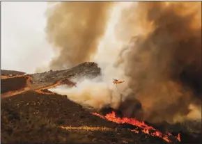  ?? MARIA ALEJANDRA CARDONA/LOS ANGELES TIMES FILE PHOTOGRAPH ?? Helicopter­s drop water on the Holy fire burning through Orange and Riverside counties near Lake Elsinore on Aug. 10.