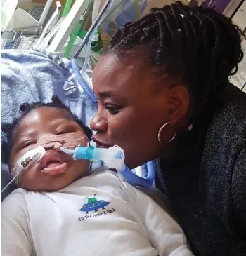  ??  ?? Ventilator: Isaiah’s aunt Dahlia Thomas comforts him in intensive care