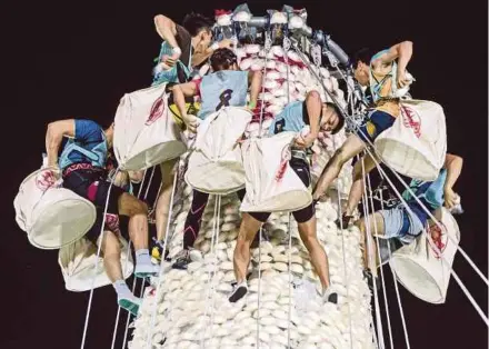  ?? AFP PIC ?? Competitor­s climbing up an 18m-high tower covered in plastic buns during the annual bun festival on Cheung Chau island, Hong Kong, yesterday.