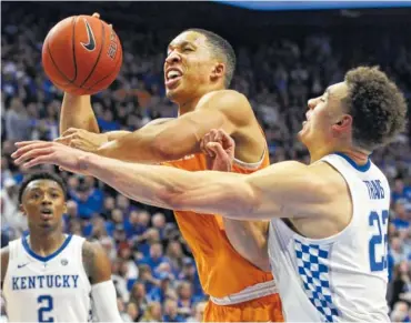  ?? AP PHOTOS/JAMES CRISP ?? Tennessee’s Grant Williams shoots while pressured by Kentucky’s Reid Travis during the second half of Saturday’s game in Lexington, Ky. Kentucky won 86-69.